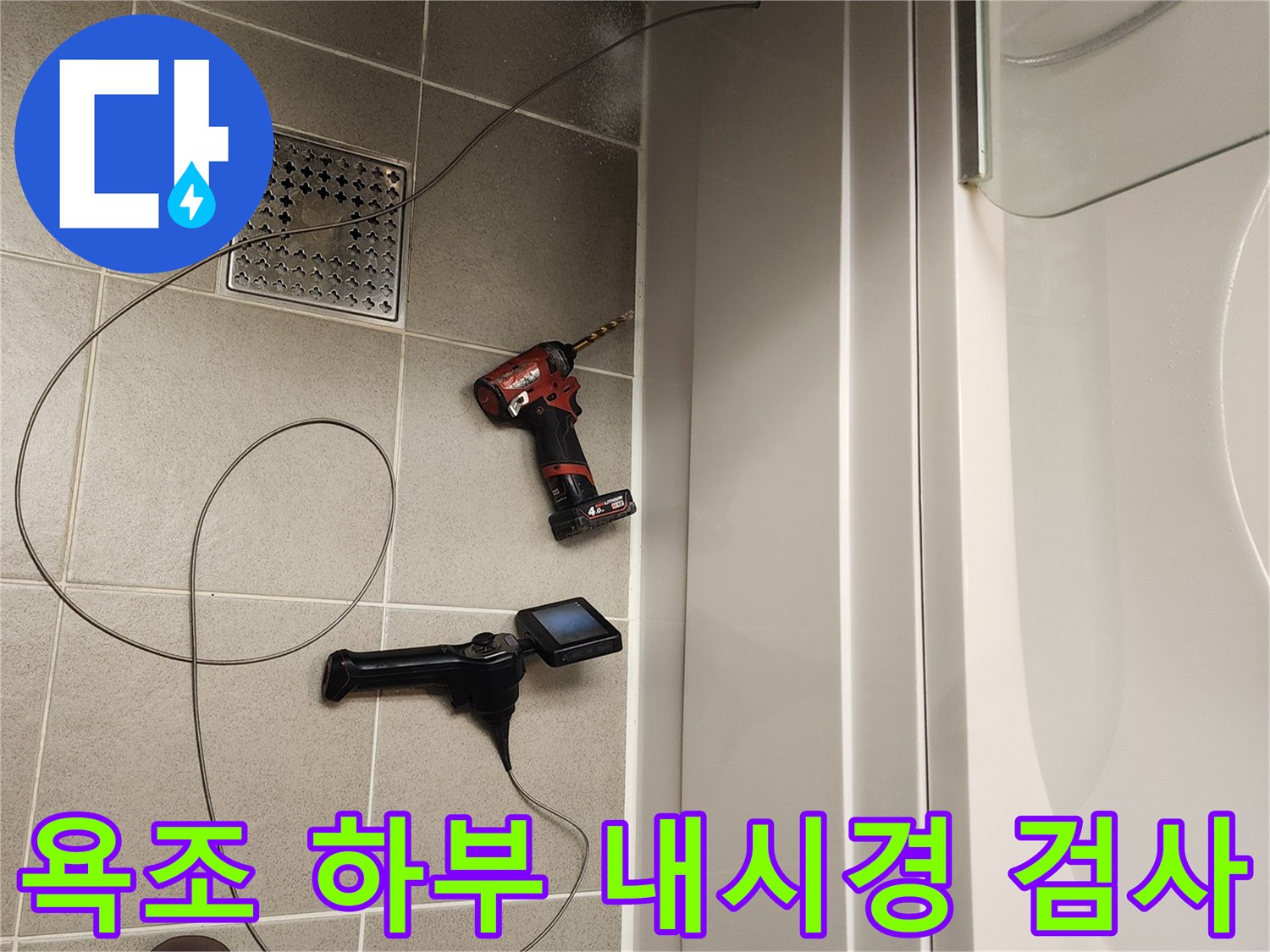 욕조 아래 배관 상태를 확인하기 위해 내시경 카메라를 투입하는 모습입니다.