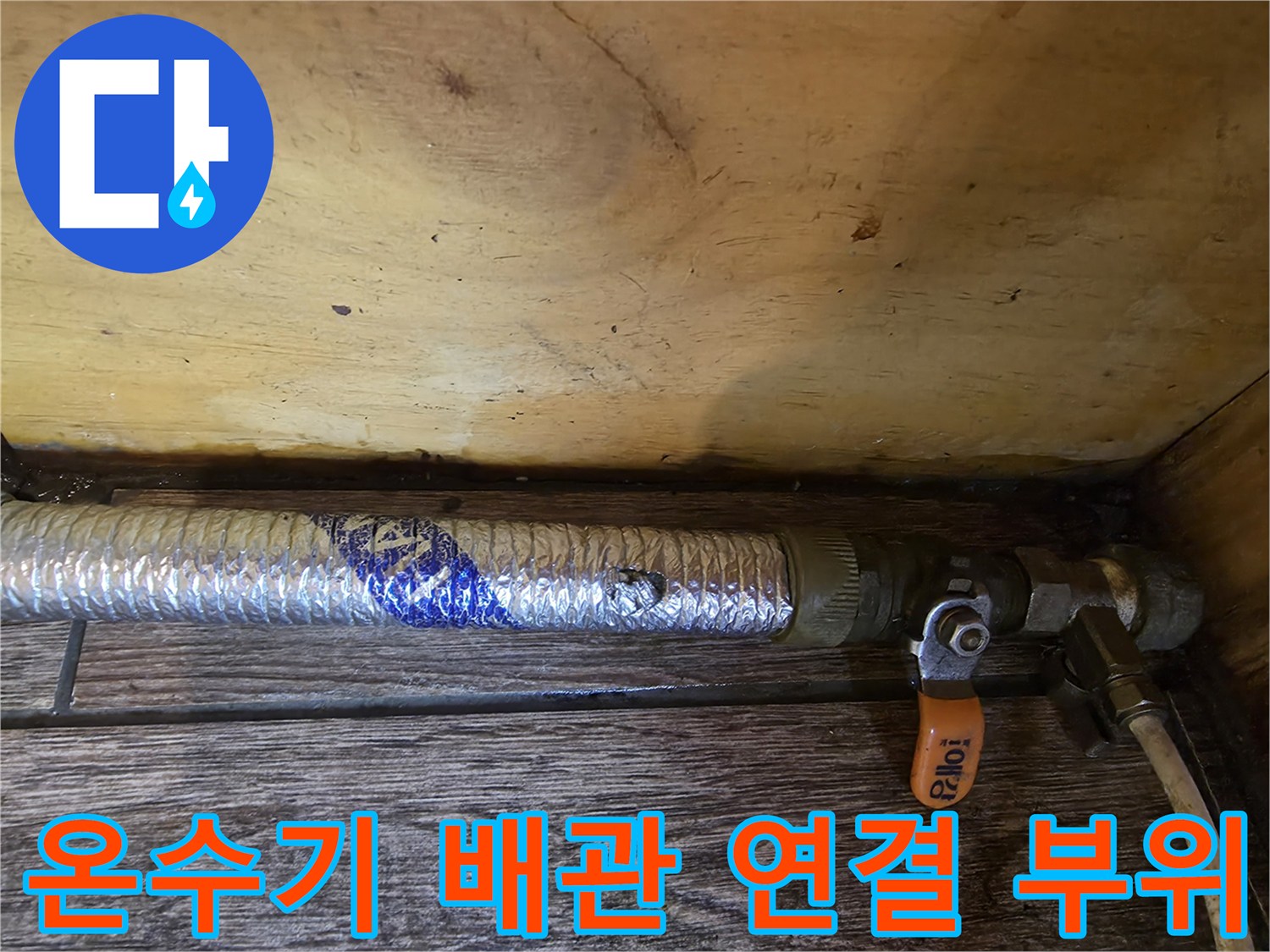 주방 온수기 아래 은박 보온재로 감싸진 배관의 상세 모습