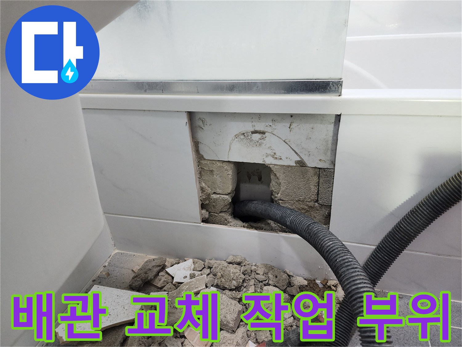 벽면 타일을 제거하고 드러난 파손된 검은색 자바라 배관