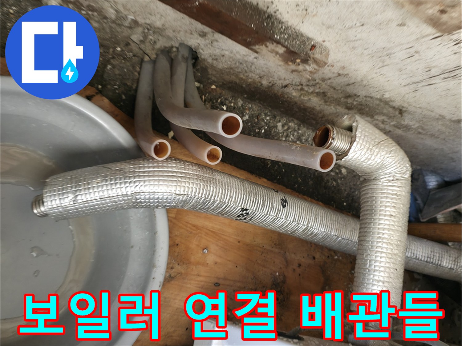 은색 보온재로 감싸진 배관과 분리된 주황색 엑셀 파이프의 근접 사진입니다.