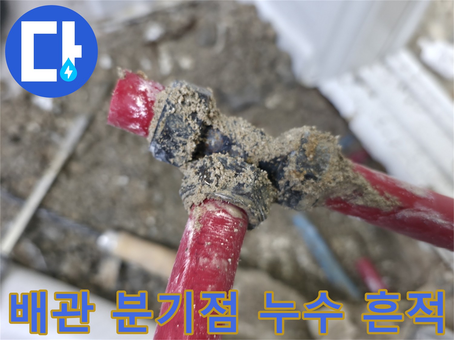 배관 분기 부속 주변에 습기와 흙이 엉겨 붙은 모습