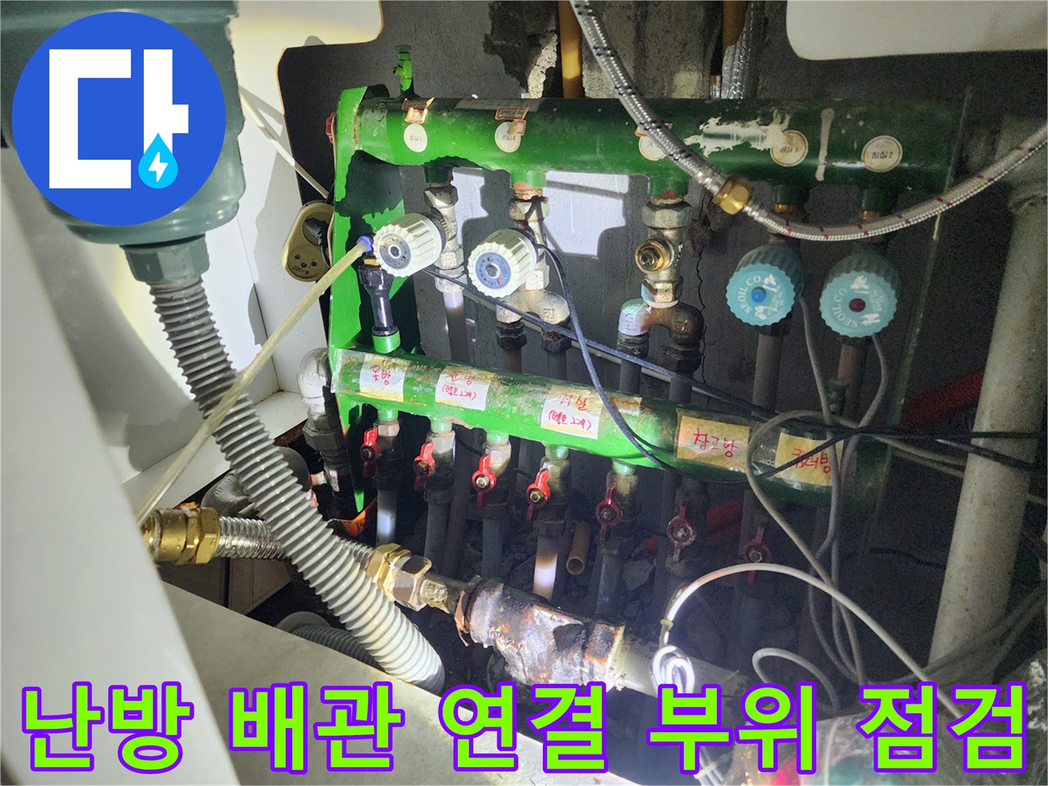 녹색 난방 배관과 파란색 밸브 핸들이 보이는 분배기 내부 모습