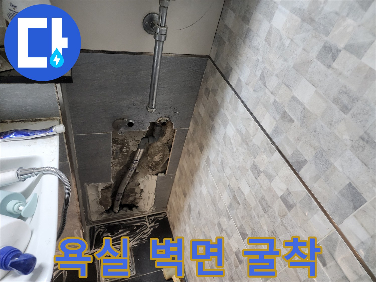 벽면 내부의 금속 배관과 젖은 콘크리트가 보이는 굴착 현장입니다.