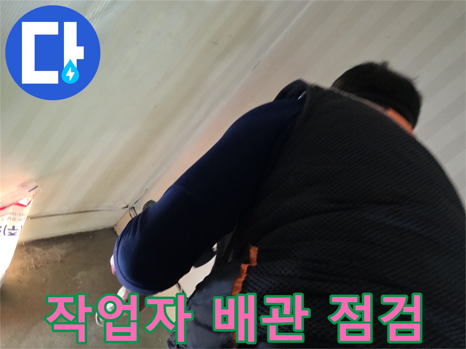 현장에서 작업자가 벽면과 바닥 경계 부근을 살피며 누수 여부를 확인하고 있습니다.