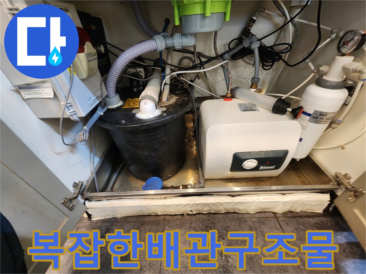 싱크대 하부의 다양한 배관과 온수기 장비들을 촬영하였습니다.