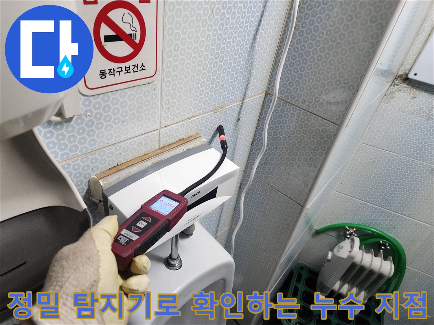 소변기 하단 배관 부근을-정밀 탐지기로 점검하는 모습