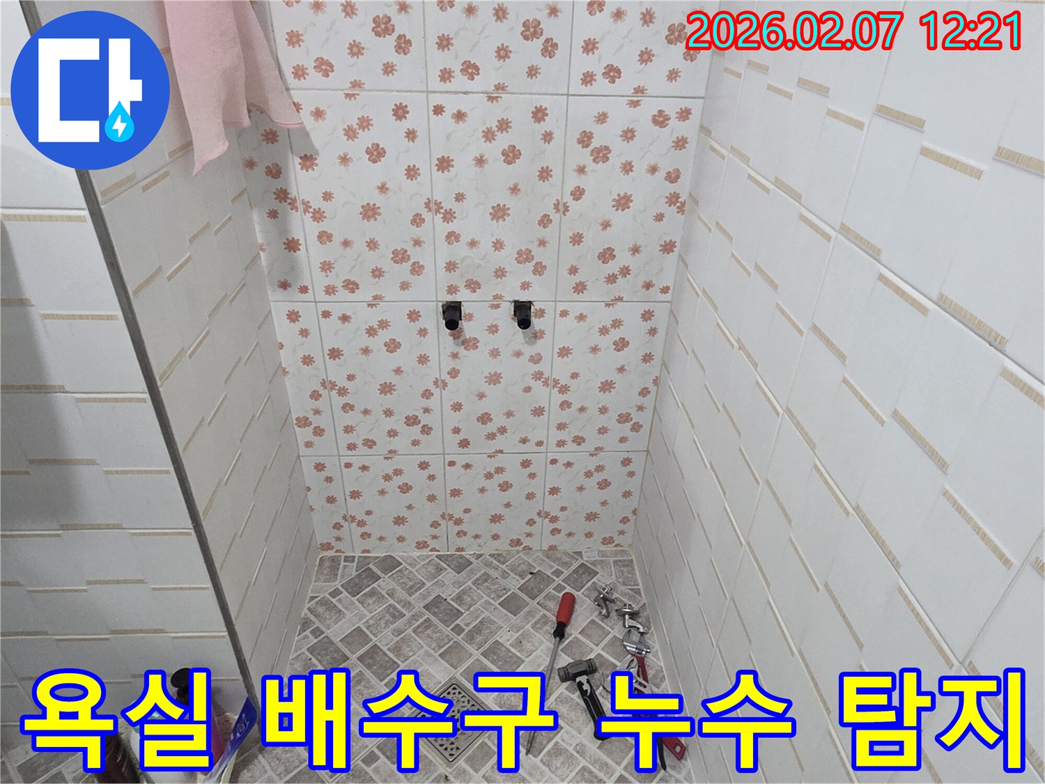 양주시 화합로 욕실에서-누수 엔지니어가-바닥 배수구 주변의 누수 여부를-정확하게 탐지하기 위해-현장을 면밀히 점검하고 있습니다