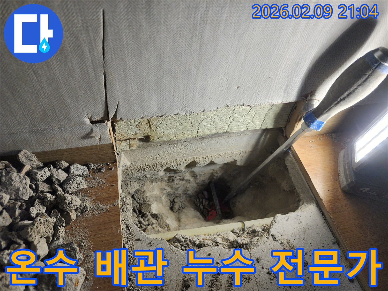 부천 원미구 아파트에서 발생한 온수 배관 누수를-전문가가 해결하기 위해-바닥을 파쇄하고-누수 지점의 온수 배관을-확인하는 작업 현장입니다.
