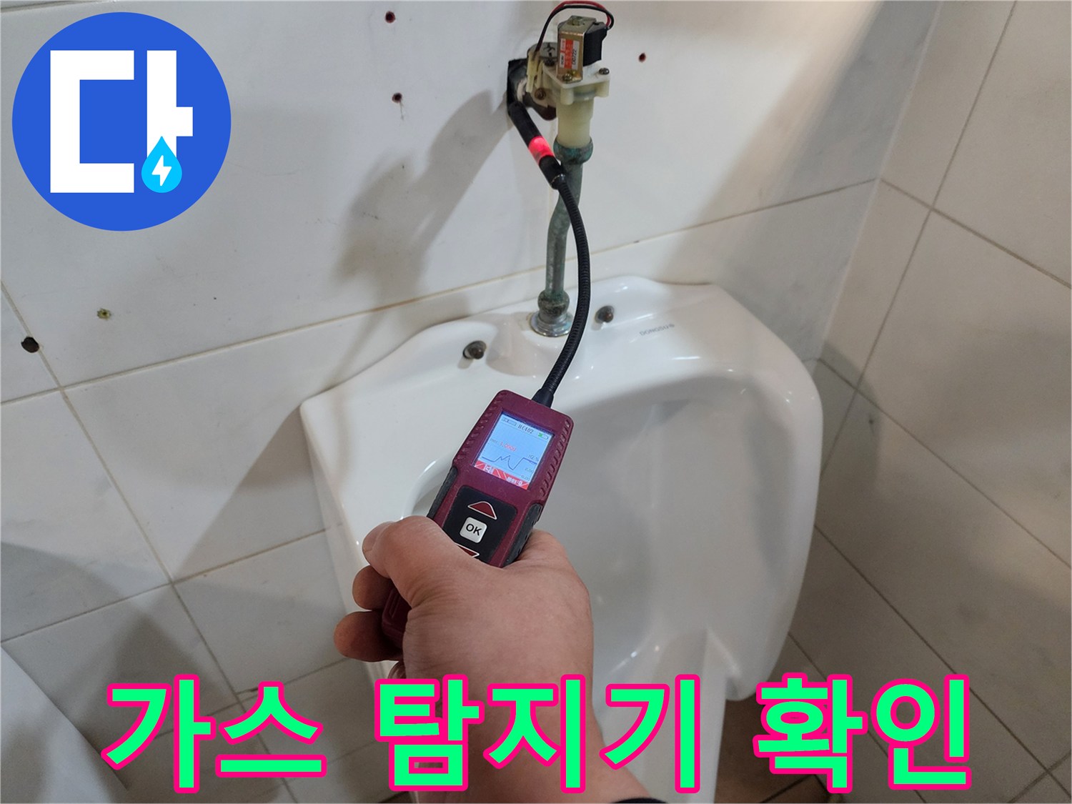 화장실 벽면 배관 상태를 점검하기 위해 가스 탐지기를 사용하는 모습