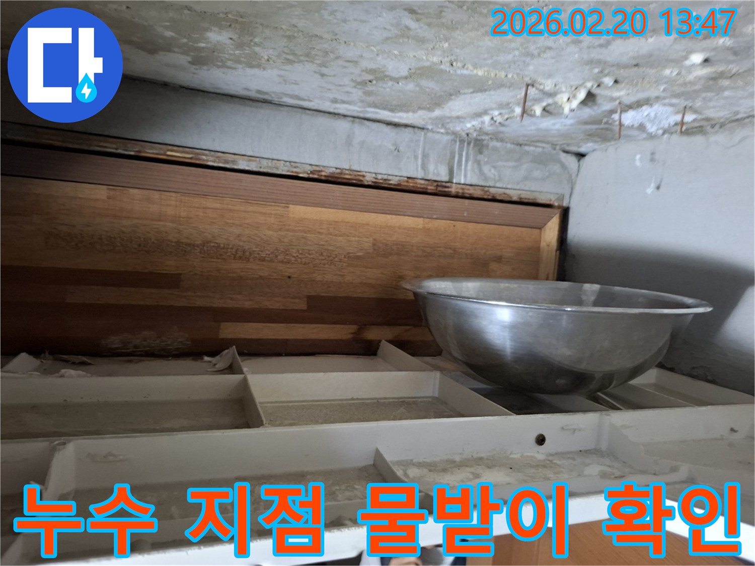 천장에서 물이 떨어져-임시로 물을 받고 있는-누수 현장의 모습이 담긴 사진입니다