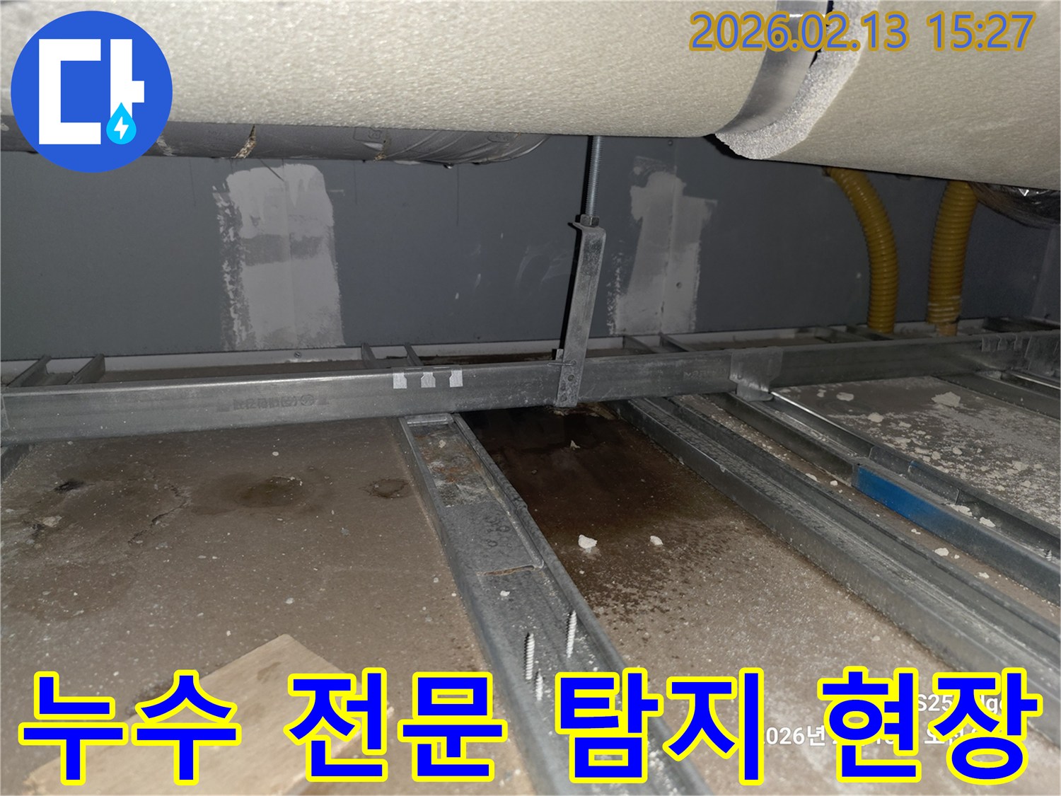 최첨단 장비로-천장 아래 바닥에 물이 고여있는-누수 현장을 탐지하는 사진입니다.