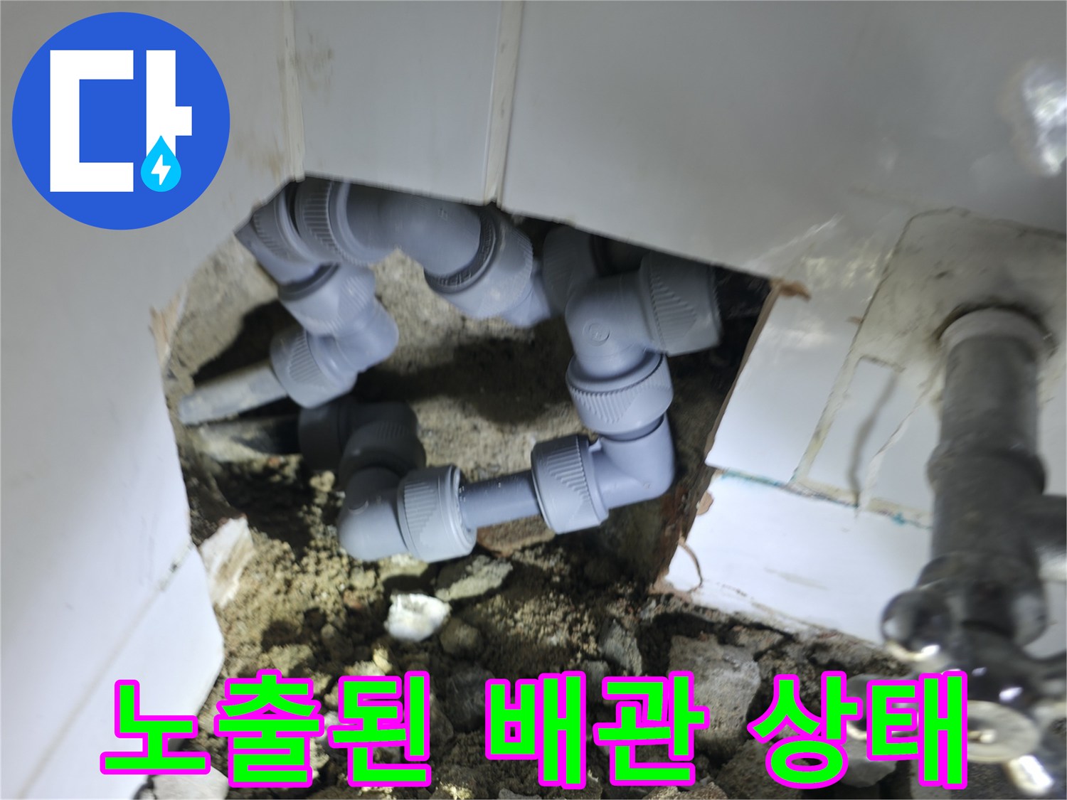 벽체 내부의 회색 배관과 금속 밸브가 노출된 모습