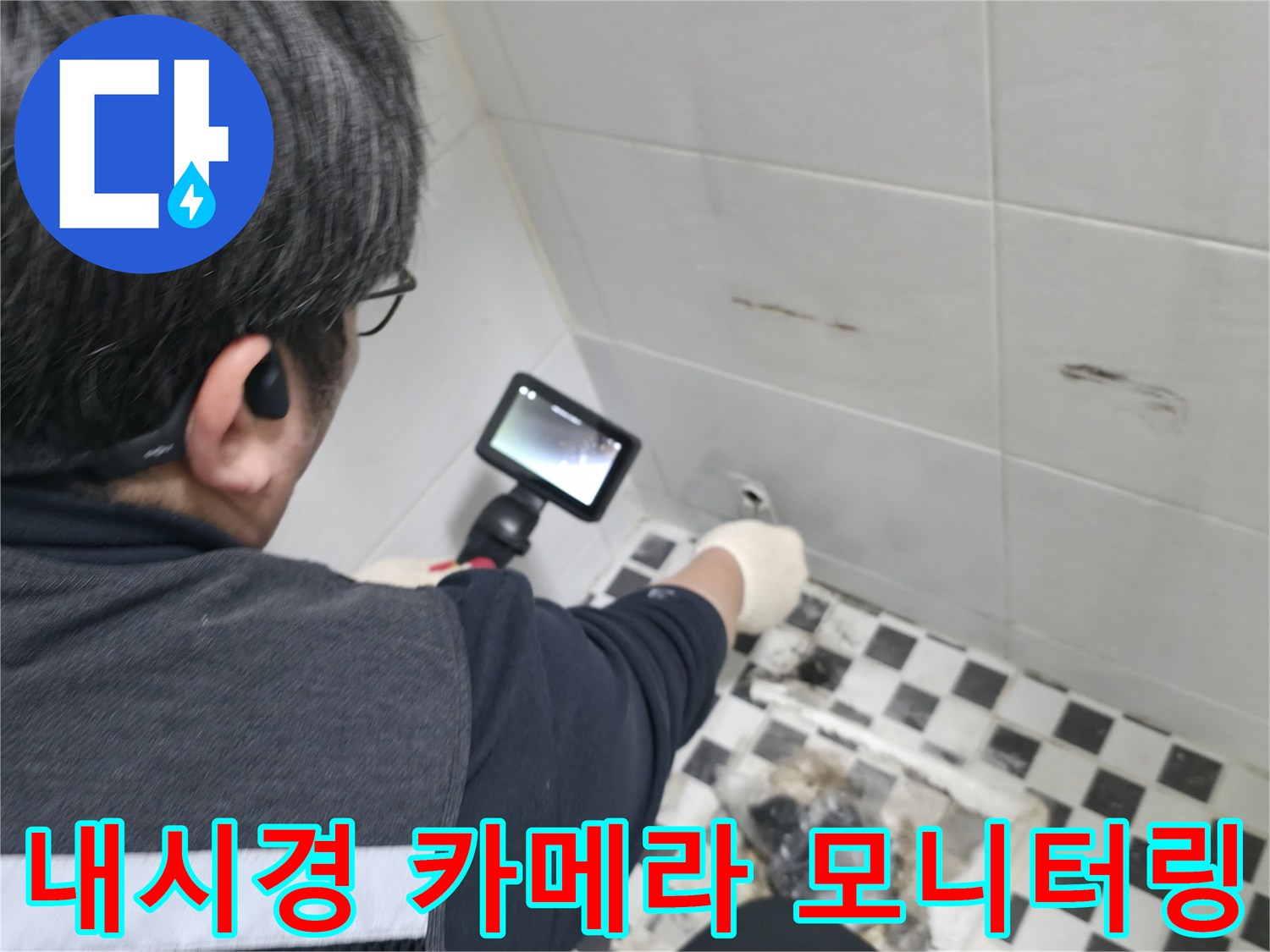 화장실 벽면의 누수 흔적을 찾기 위해 내시경 장비를 운용하는 모습
