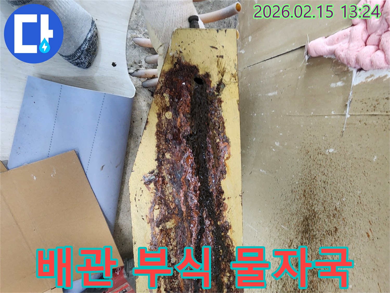 빌라-누수-현장에서-부식된-배관으로-인한-명확한-물자국을-전문가가-확인하고-있습니다