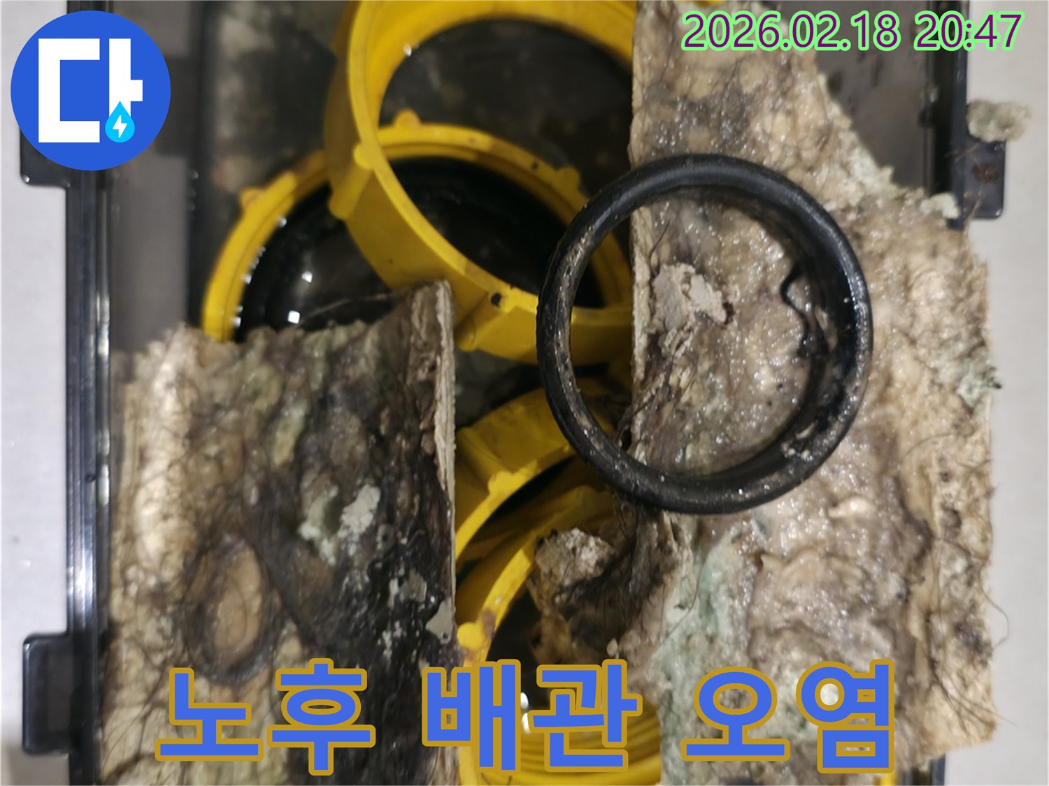 노후-배관-교체-과정에서-발견된-오염물과-심하게-부식된-부품을-보여주는-사진입니다