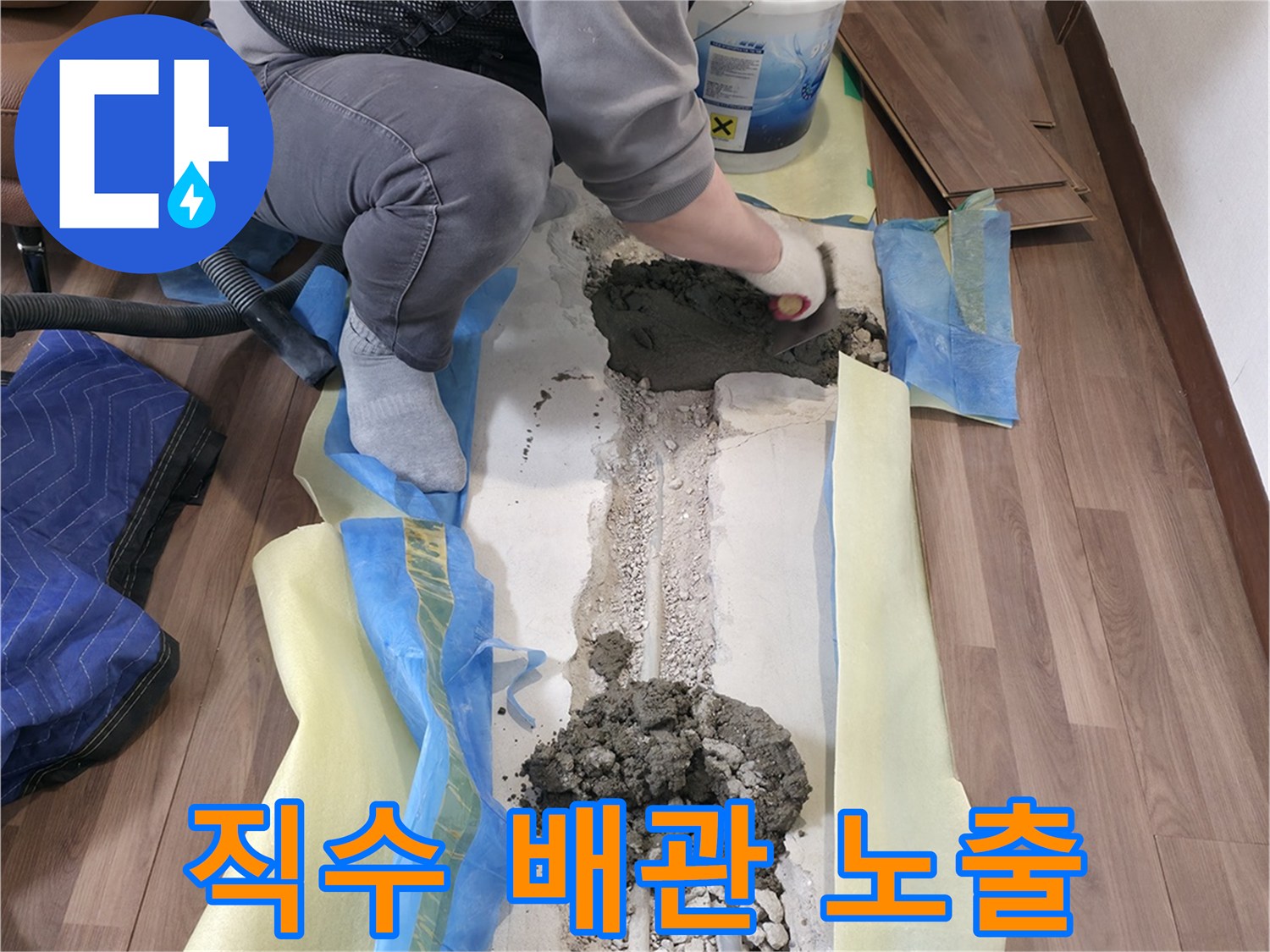 굴착된 바닥 틈새에 보이는 파손된 직수 배관과 주변 자갈층