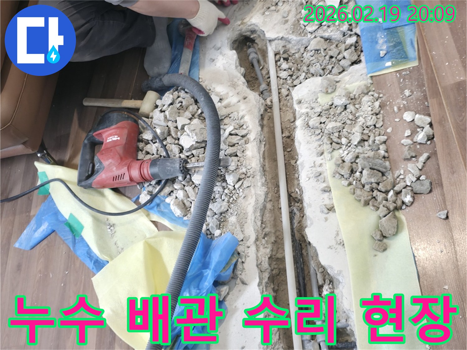 아파트-누수-현장에서-바닥을-파쇄하여-배관을-노출시키고-수리-작업을-진행하는-모습