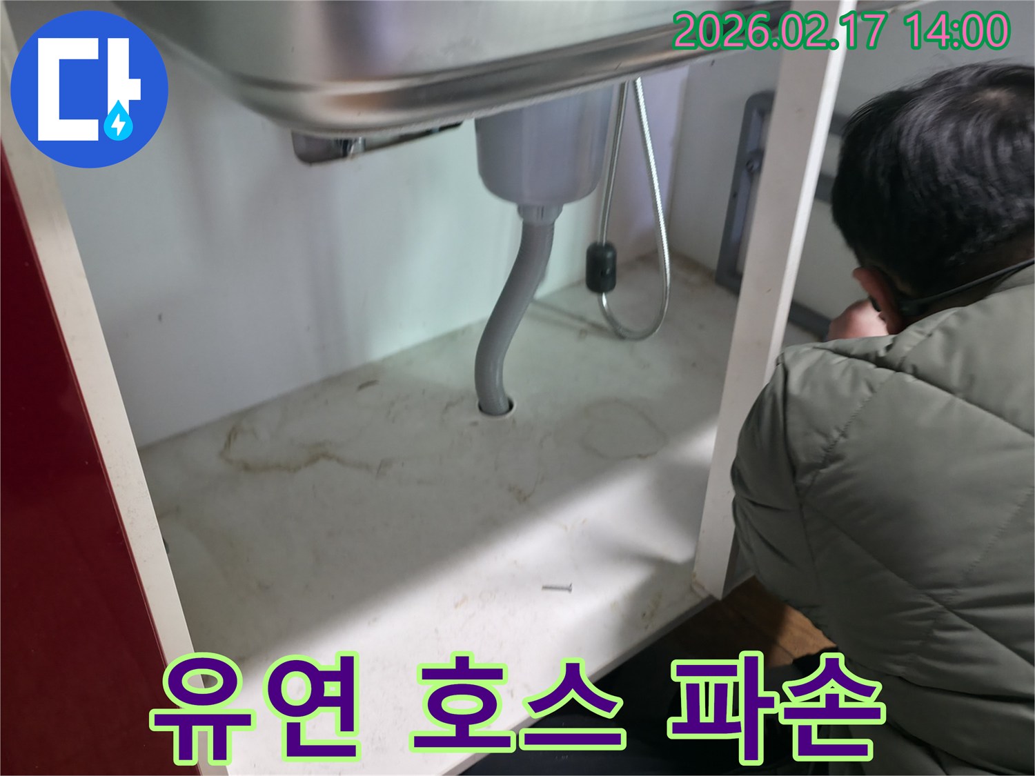싱크대 배수관으로 사용된-유연 호스의 파손 여부를-확인하며 누수 원인을-찾아내는 엔지니어의 모습