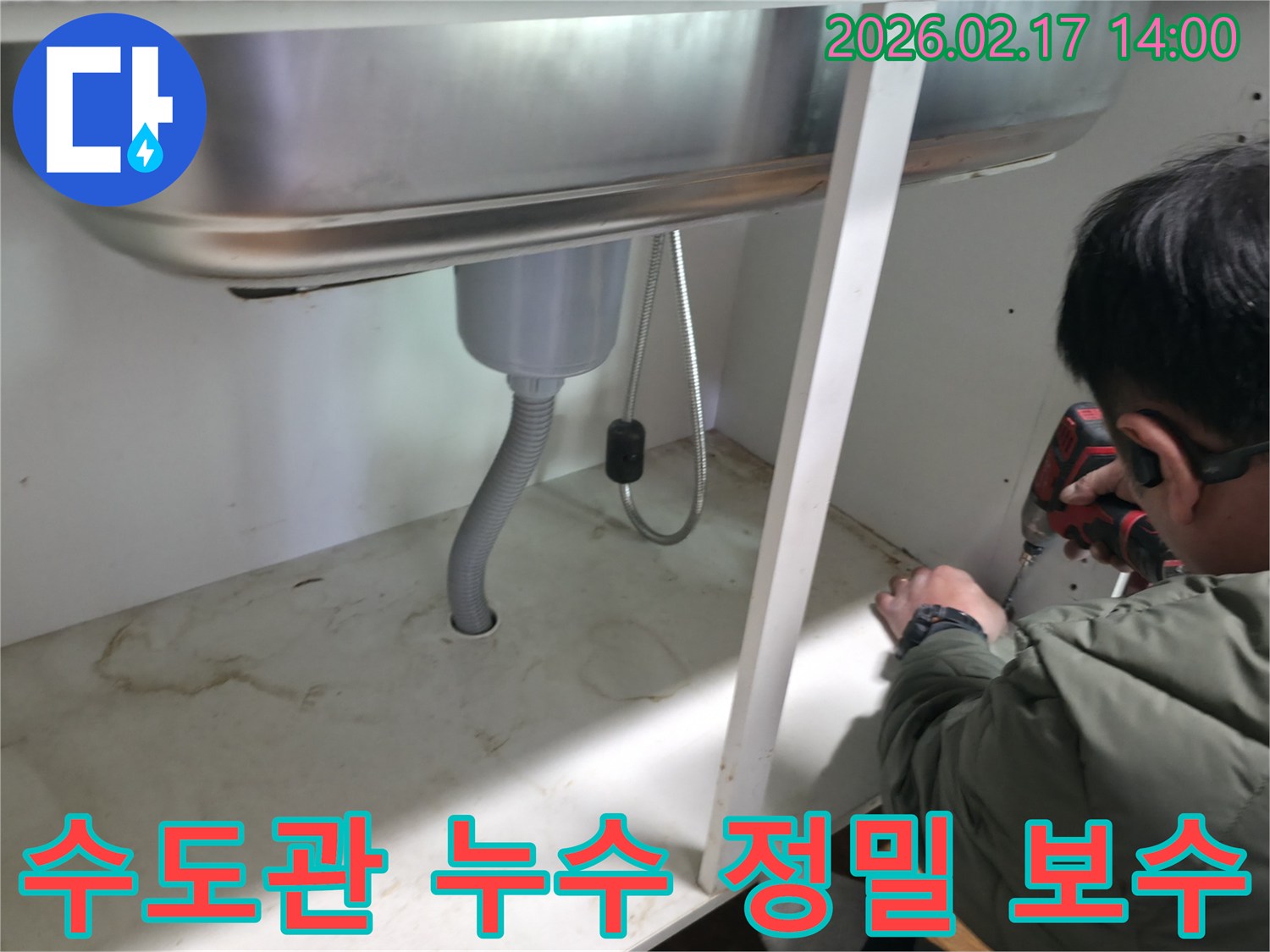 싱크대 아래 수도관에서-발견된 미세한 누수 지점을-전문가가 정밀하게 보수하는 모습
