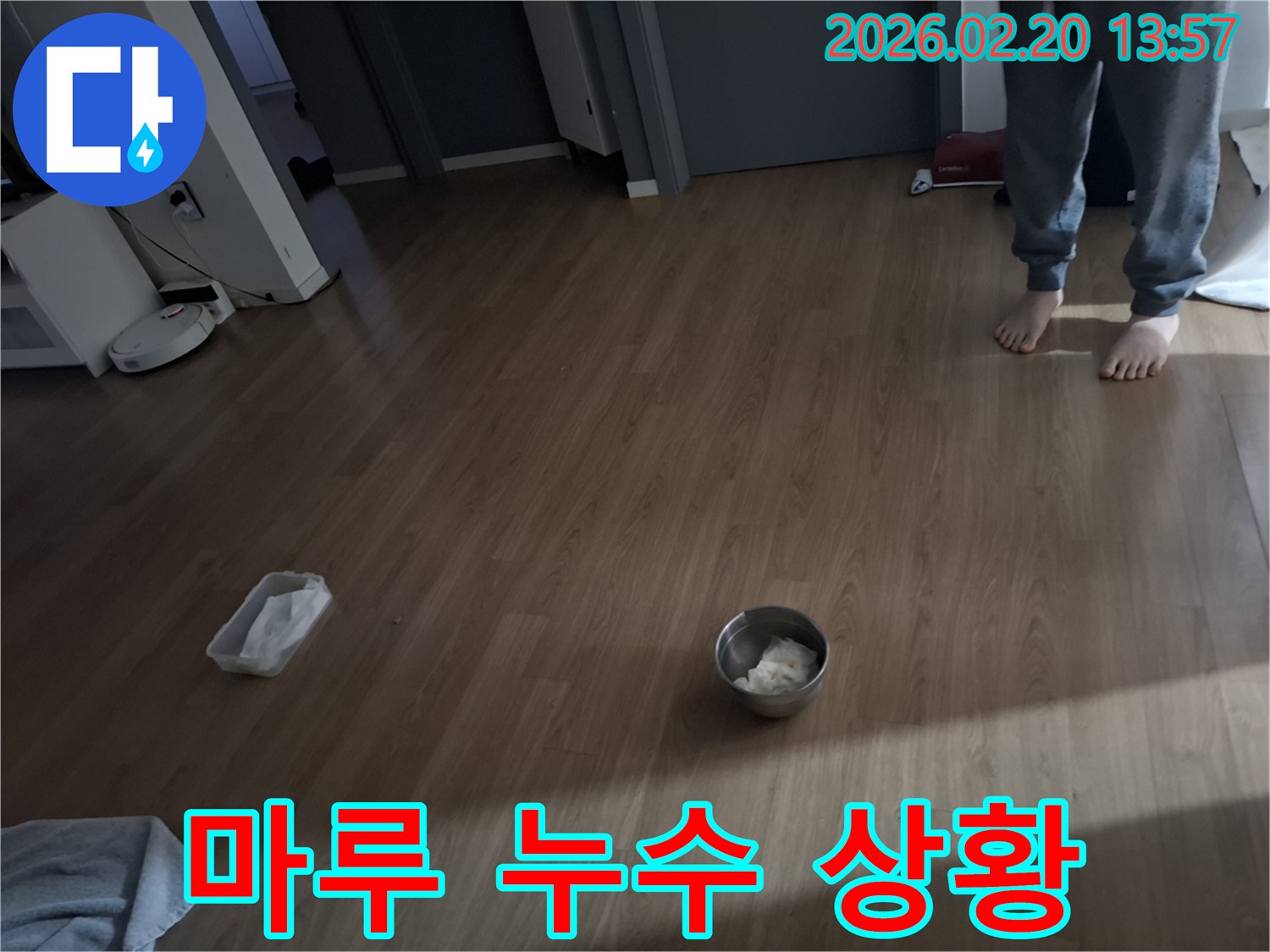 누수 발생으로 바닥에 물이 새어 나와 임시로 그릇을 놓아둔 현장 모습-전문가가 방문하여 누수 원인을 파악하기 전의 상황