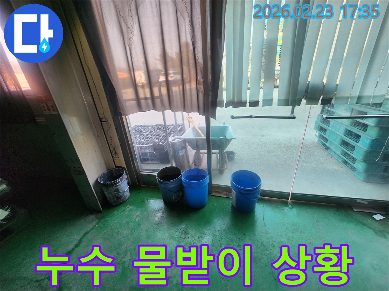 누수 현장에서-물이 새는 것을 막기 위해-파란색과 회색 양동이가-놓여 있는 모습