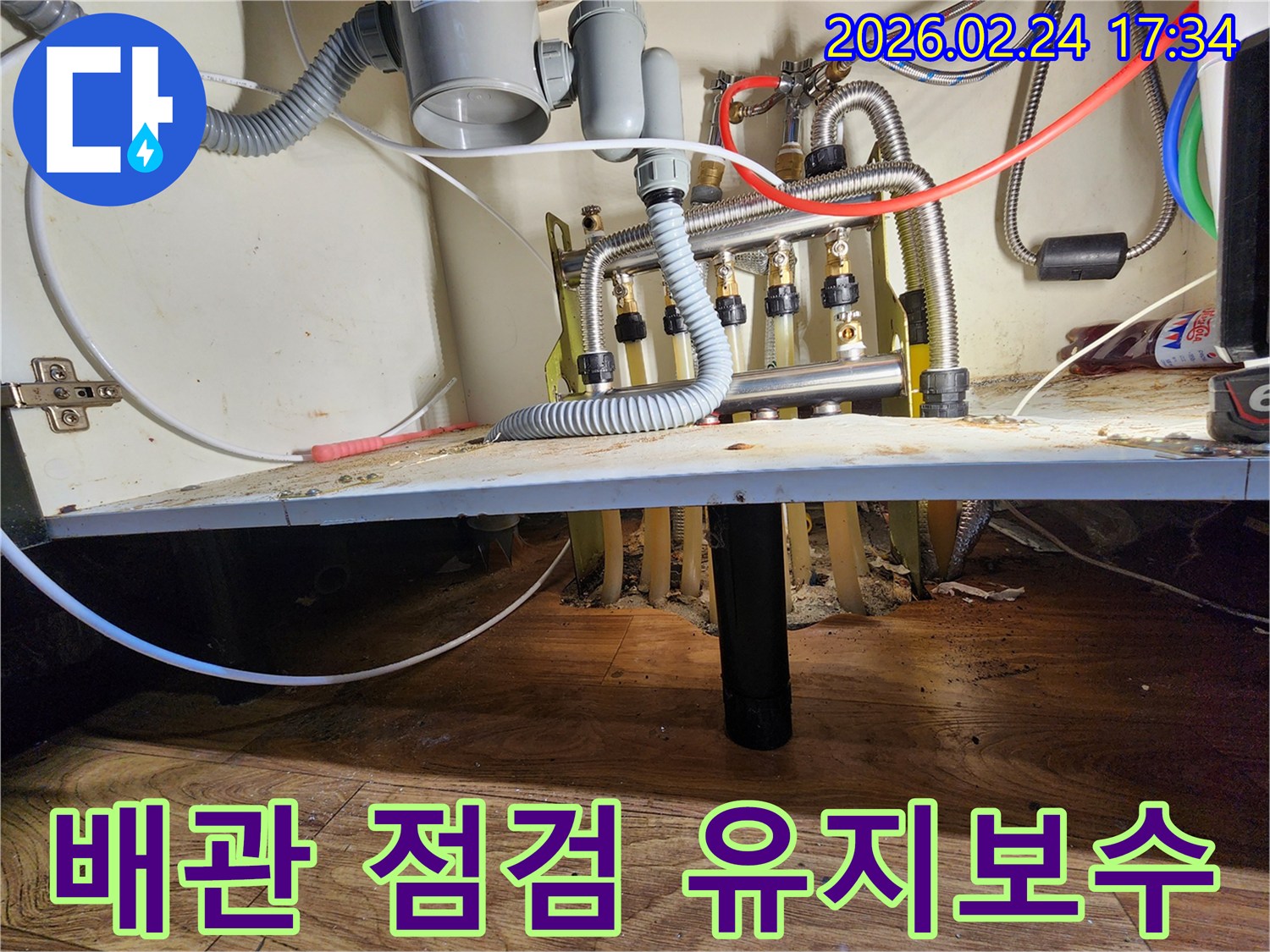 싱크대 하부의-배관 시스템을-누수 방지를 위해-전문가가 점검하고-유지보수하는 모습
