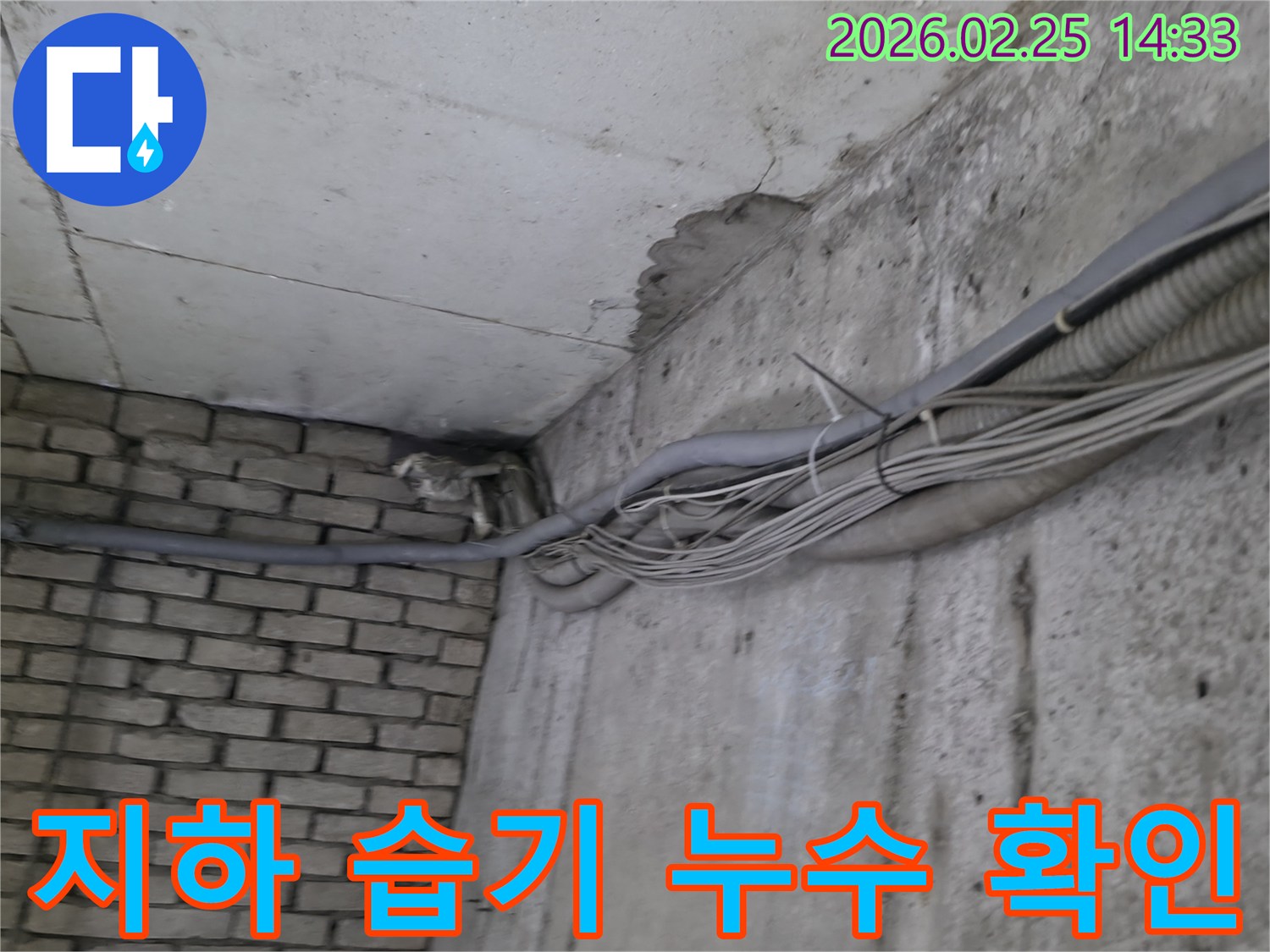 건물 지하의-콘크리트 벽과-벽돌 벽이 만나는-구석에서-발견된-오래된 물샘의-흔적과 주변 배관
