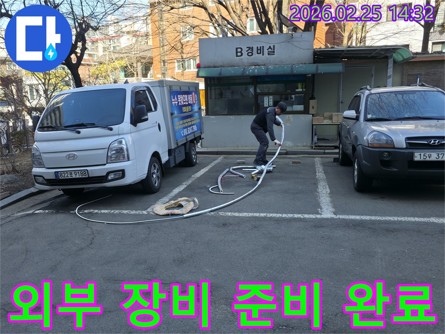 누수 전문 엔지니어가 건물 내부 진입에 앞서-모든 탐지 장비를 외부에서 완벽하게 준비하고 있습니다.