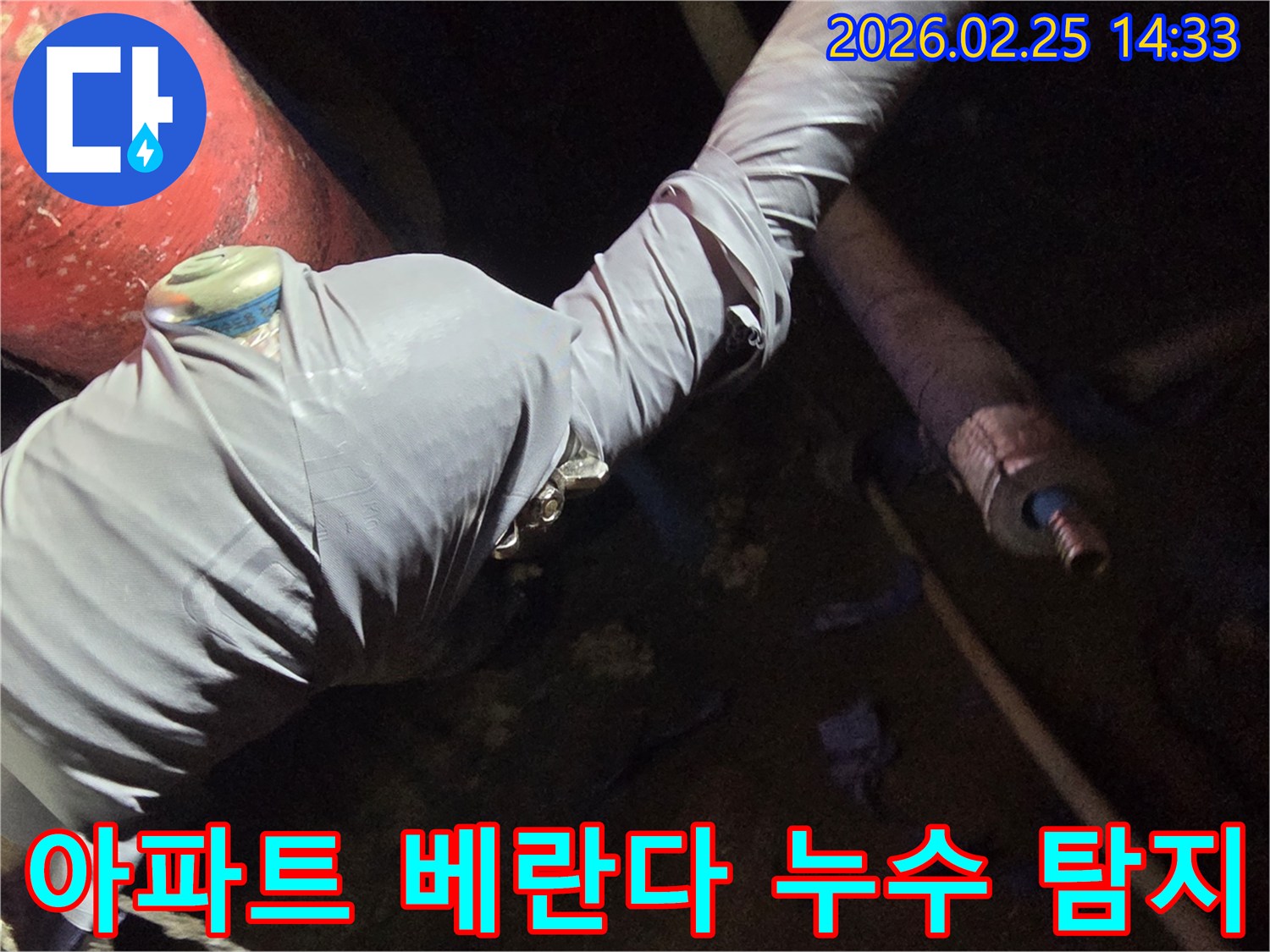 누수-전문가가-아파트-베란다-누수-원인을-찾기 위해-배관에-탐지-장비를-연결하는-사진