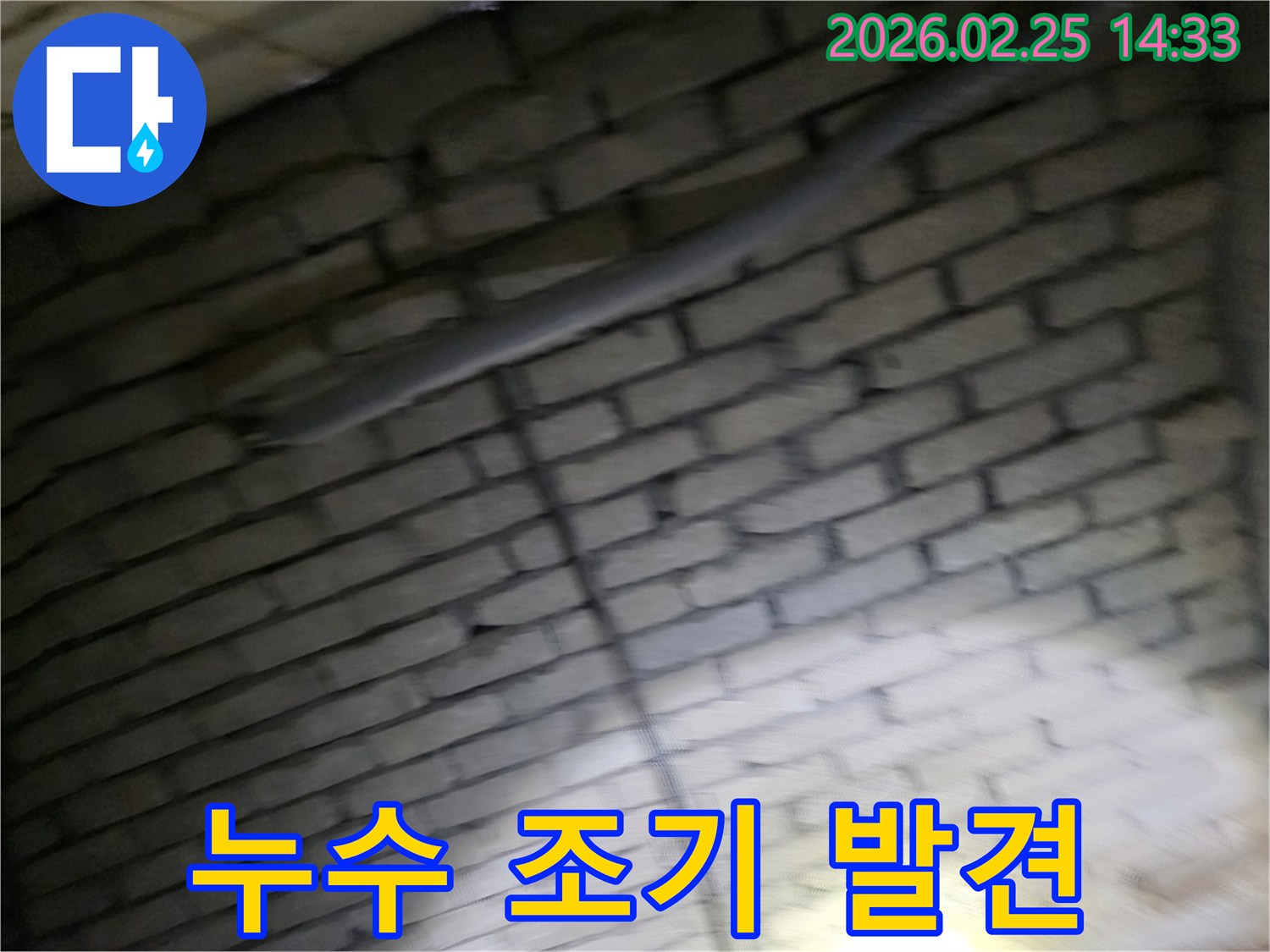 어두운-벽돌벽-내부의-배관에서-발생한-누수를-조기에-발견하여-더 큰-피해와-비용을-절감하는-것의-중요성을-설명하는-전문가의-모습