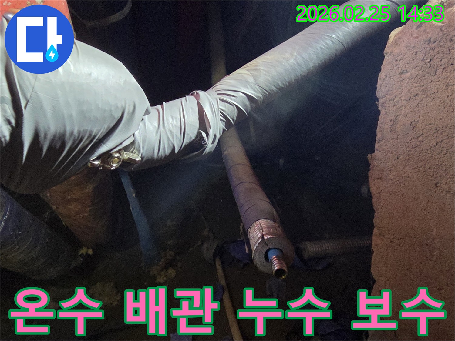 어두운 작업 공간에서-장갑을 낀 손이-보온 처리된 온수 배관의-누수 지점을-정확히 찾아내어-보수하는 모습입니다