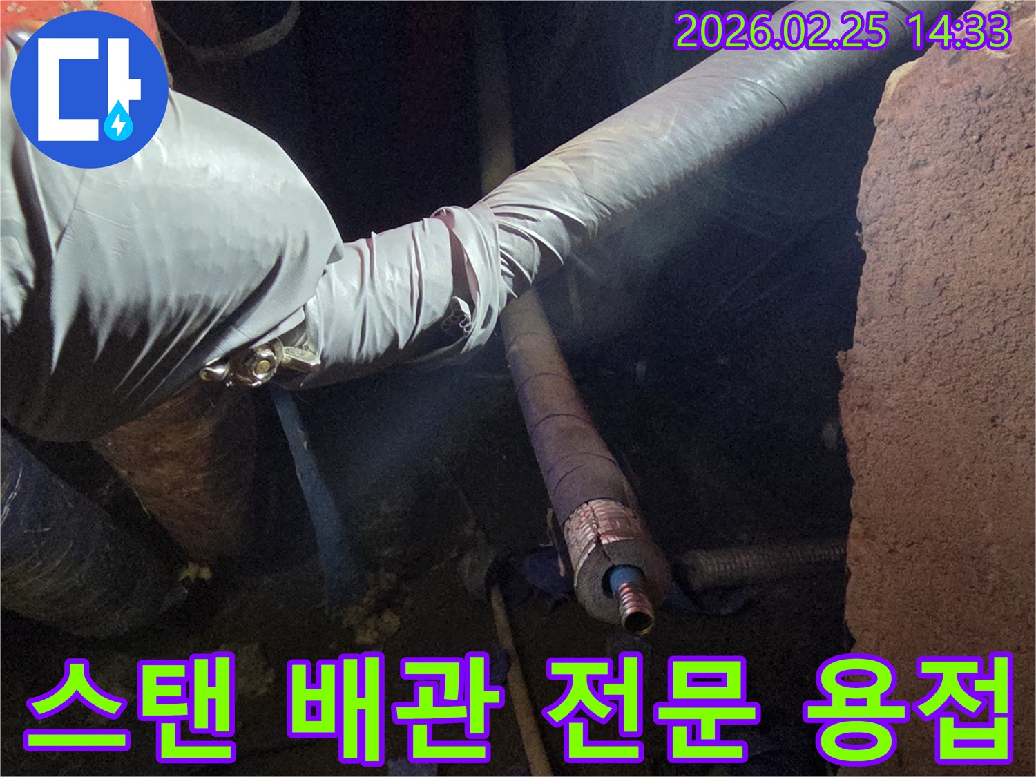 어두운 작업 공간에서-장갑을 낀 손이-스탠 배관의-손상된 부분을-전문 용접 기술로-견고하게 보수하는-모습을 담고 있습니다