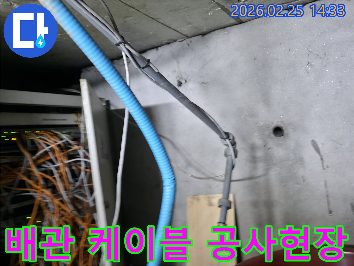 이 이미지는 누수 공사 현장에서-복잡하게 얽힌 배관과 케이블이-콘크리트 벽면을 따라 설치된 모습을 보여줍니다-이는 미세 누수 탐지의 어려움을 나타냅니다
