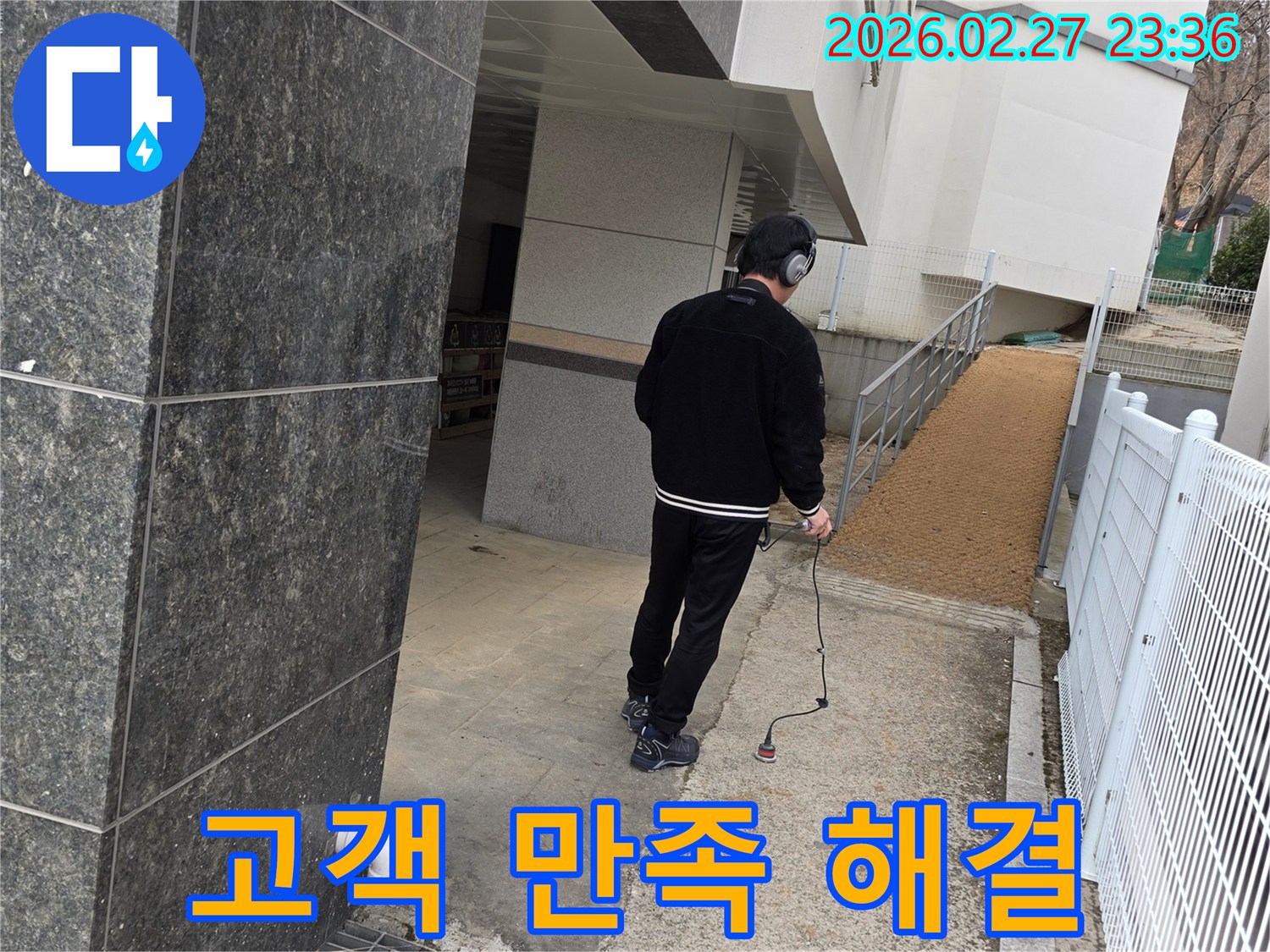 누수 엔지니어가-청음식 탐지 장비로-건물 외부의-누수 지점을 찾아내어-고객 만족을 위한-해결의 첫 단계를 진행하는 모습