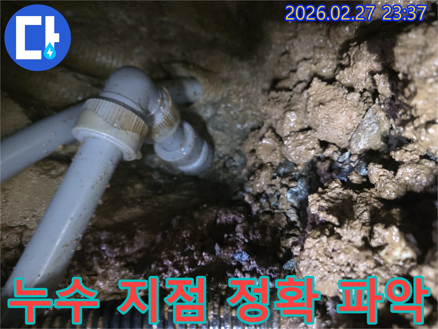 젖은 흙 속에 드러난-배관의 누수 지점을-정확히 보여주는 이미지