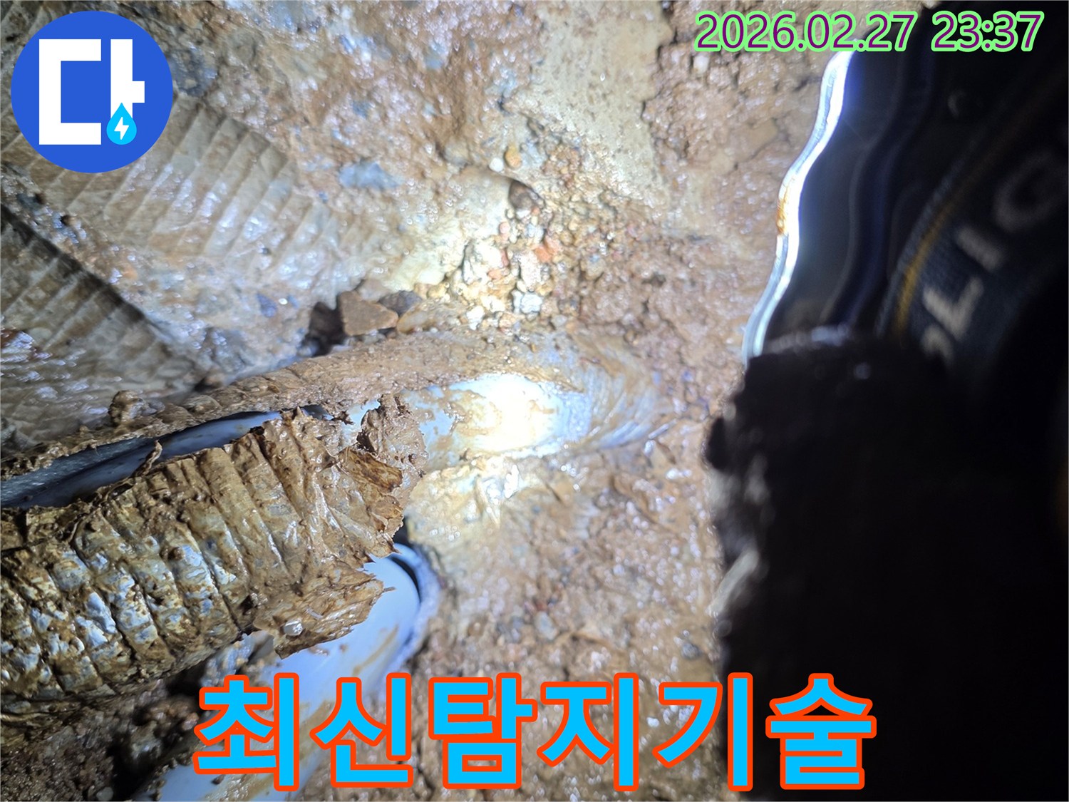 지하-매설된-배관에서-물이-새어나와-주변-흙이-진흙으로-변한-상황을-보여주는-사진으로-최신-탐지-기술의-필요성을-강조합니다