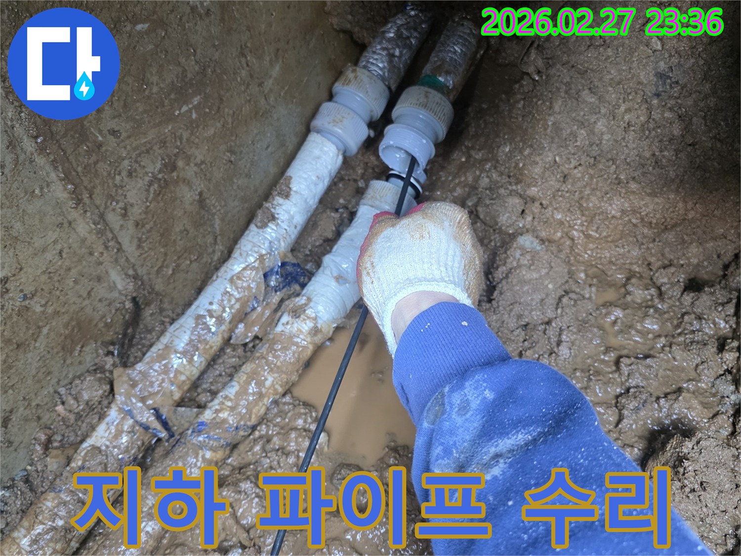 흙 속에서 진행되는 어려운 배관 작업을-안전하게 마무리하는 기술자의 모습입니다