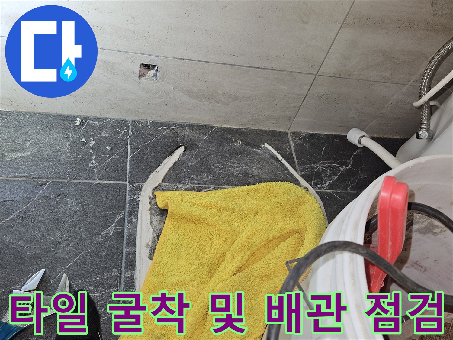 굴착된 타일 주변에 놓인 노란 수건과 작업 도구들