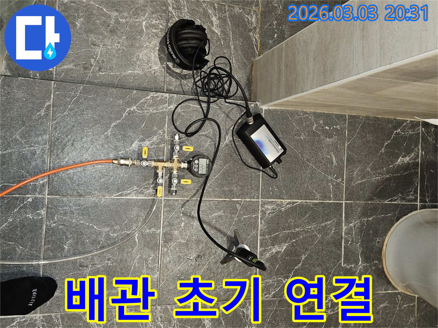 아파트 배관 시스템에-누수 탐지 장비를 초기 연결하여-진단을 시작하는 현장입니다.