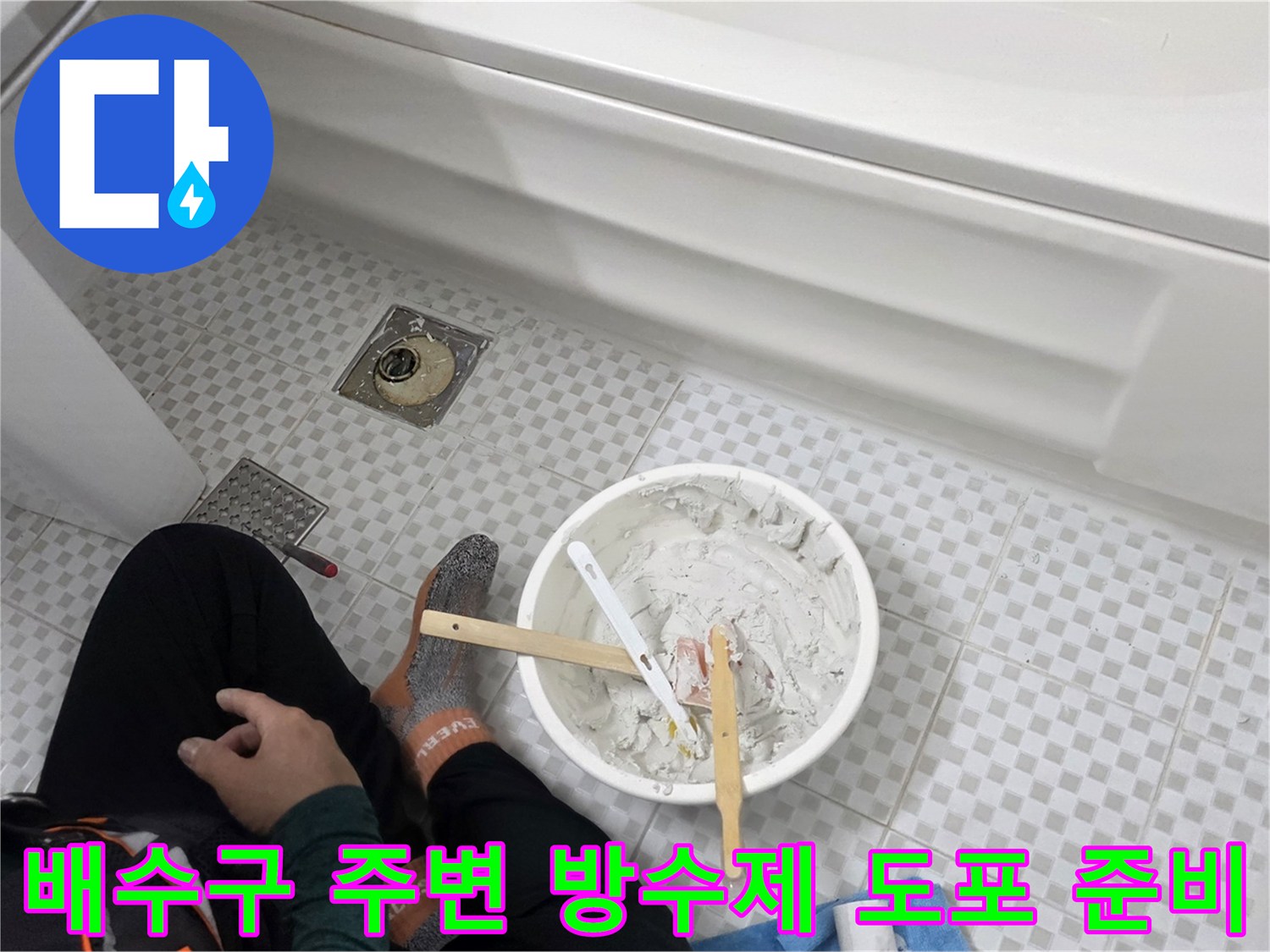 방수 반죽과 붓이 놓여 있는 욕실 바닥 작업 모습
