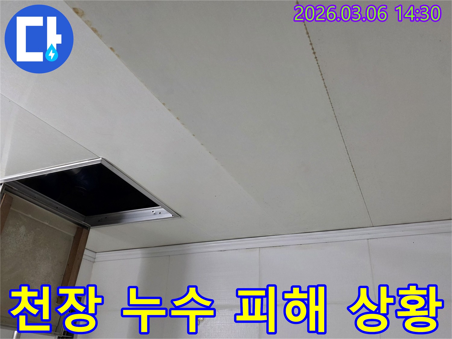 천장 마감재에 생긴 누수 흔적과-개방된 점검구를 보여주는-누수 현장 사진