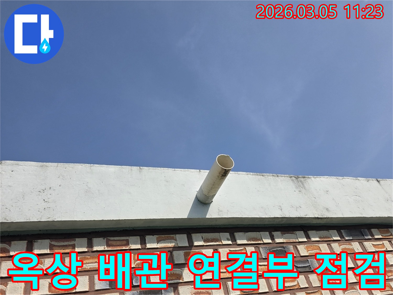맑고-푸른-하늘-아래-건물-옥상-난간에서-외부로-나온-배수관의-상단부-사진입니다.