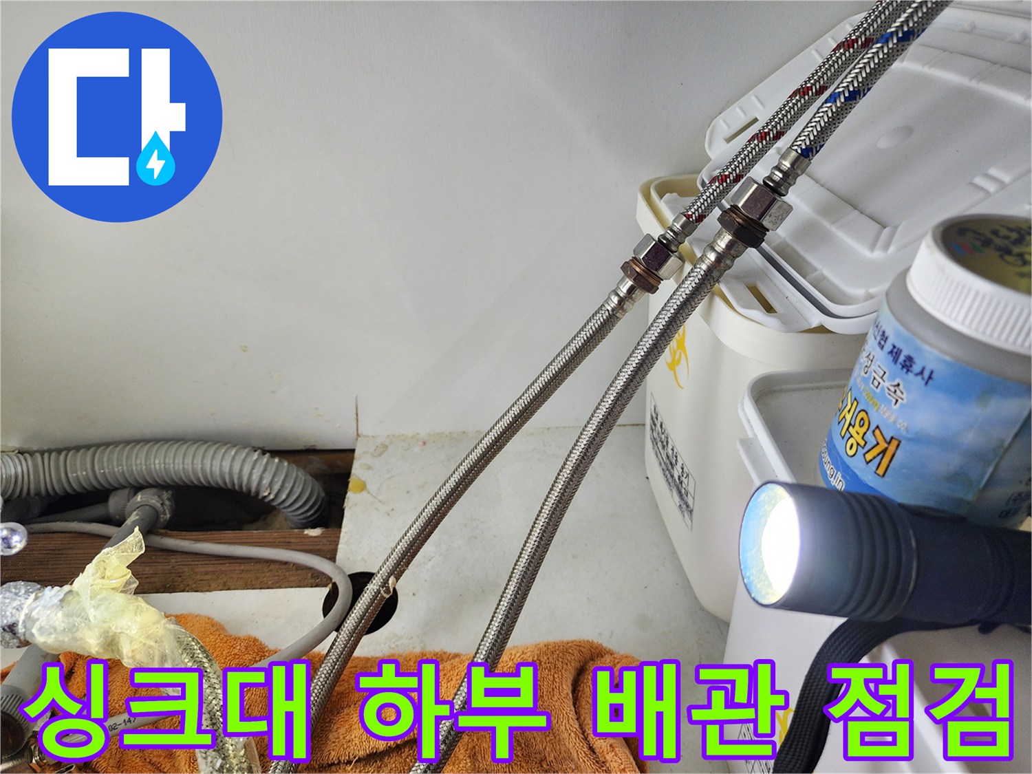 손전등으로 비춘 싱크대 하부 고압 호스 연결 부위