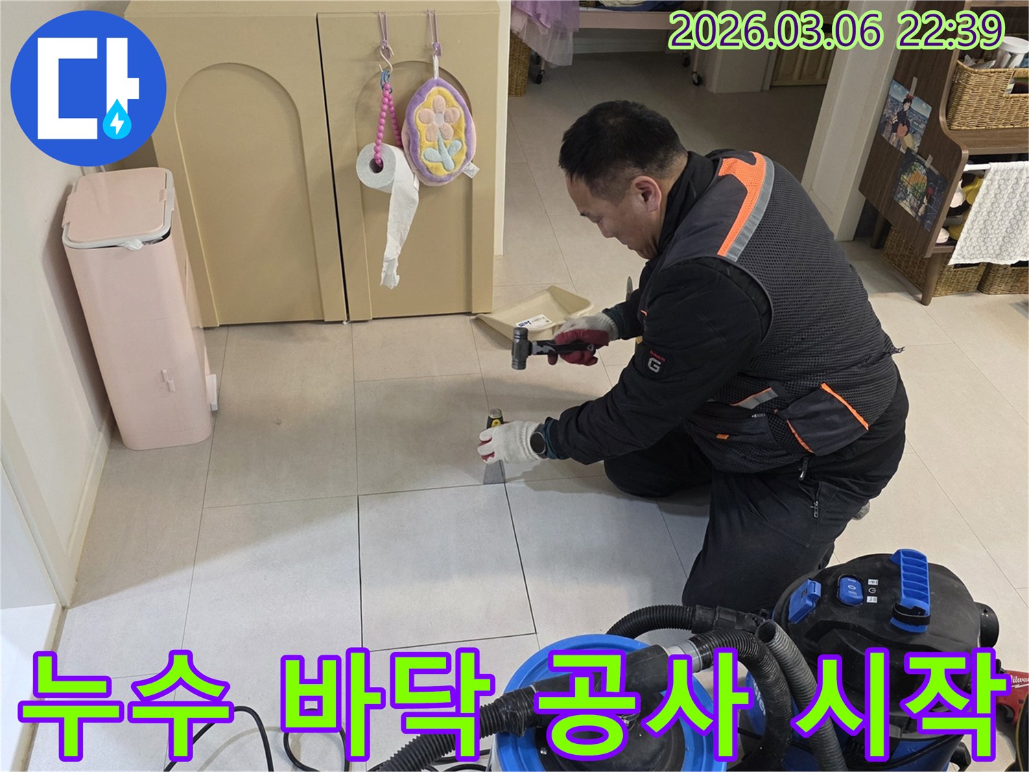 누수 전문가가-바닥 아래 숨겨진 배관을 점검하고자-타일 개봉 작업을 진행하고 있습니다.