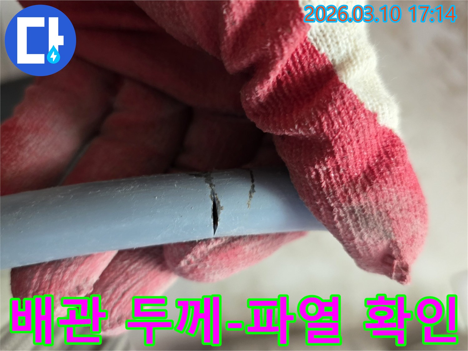 작업용 장갑을 낀 손이-파열된 배관의 두께를 확인하며-내구성 문제를 점검하고 있습니다