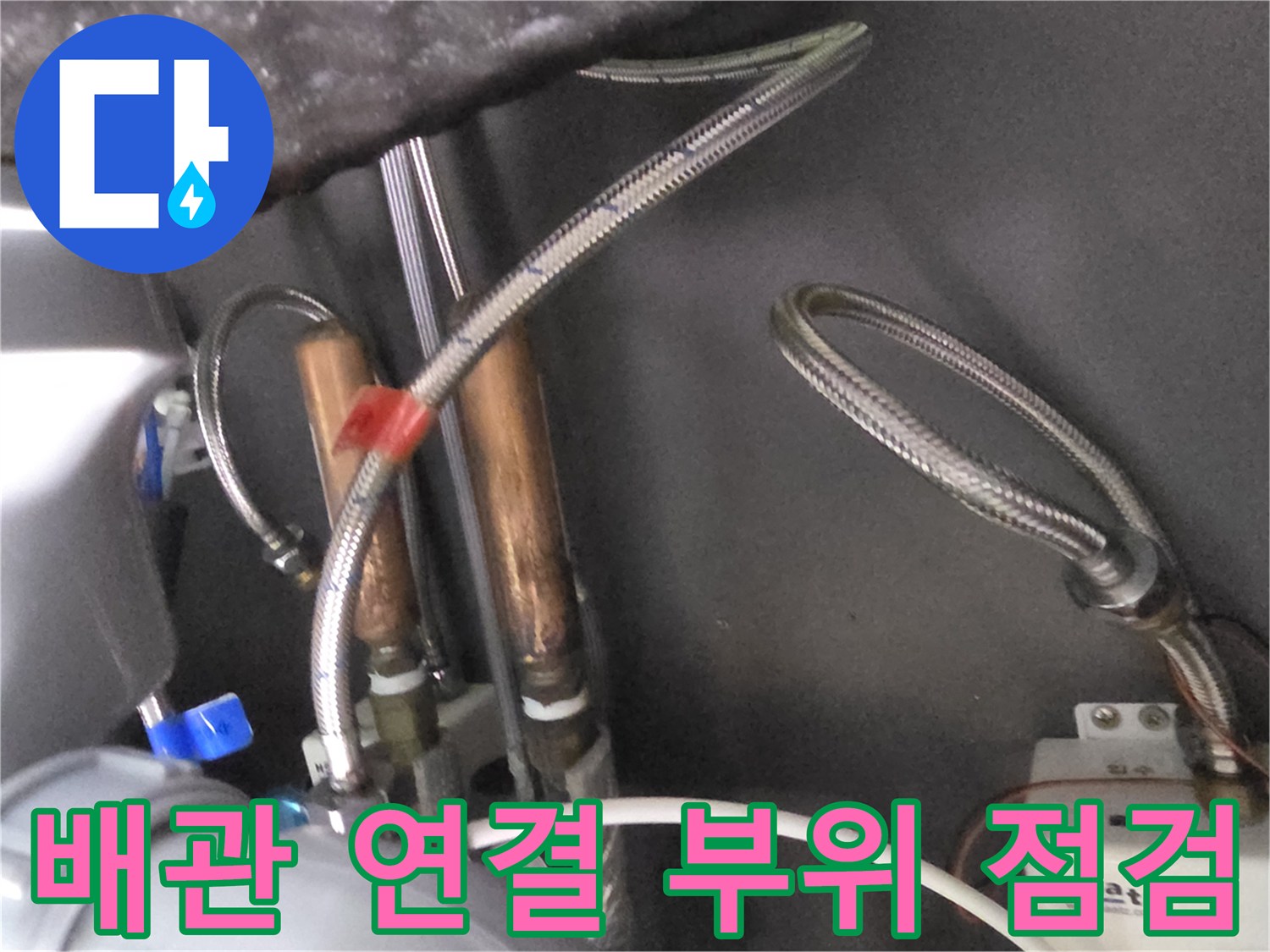 보일러실 내부-금속 호스와 구리 관이 만나는 지점의 근접 사진