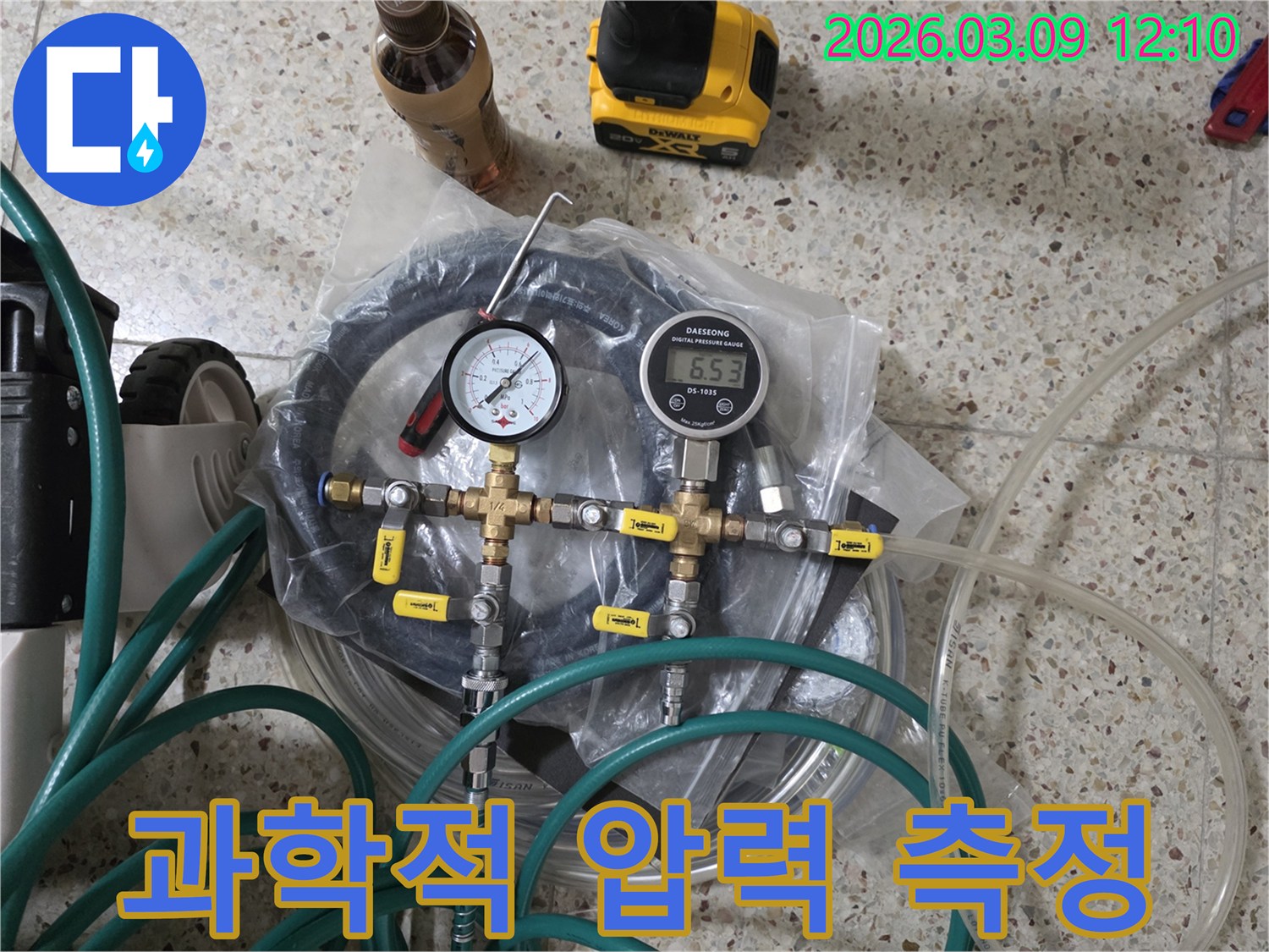누수 지점을 정확히 파악하기 위해-배관의 압력을 측정하는-디지털 및 아날로그 게이지와-연결 부품들이 바닥에 준비되어 있습니다.