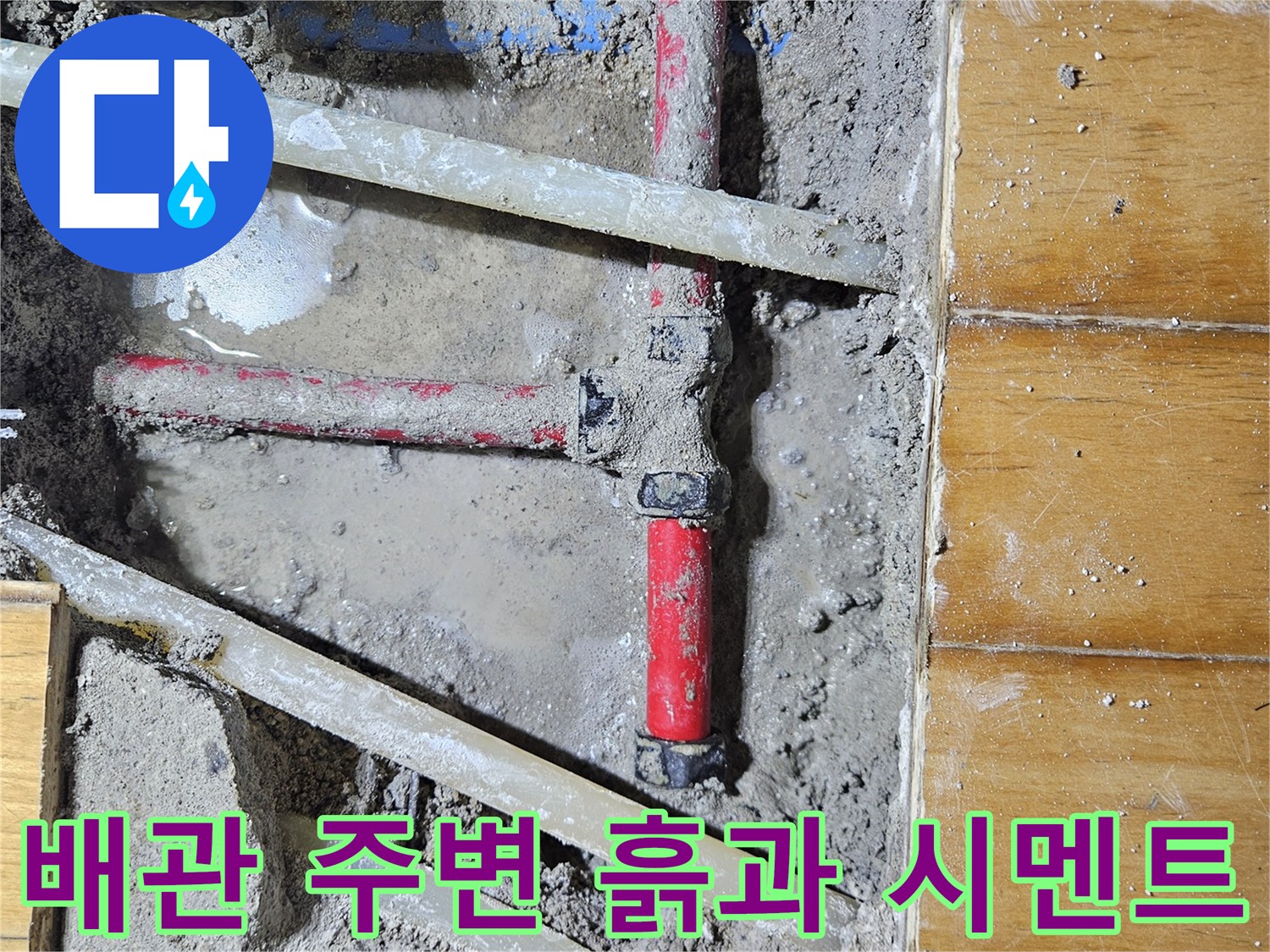 시멘트와 흙이 드러난 굴착 현장의 배관 모습입니다.