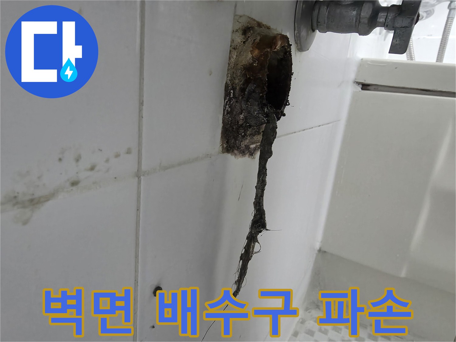 화장실 타일 벽면에 노출된 부서진 배관 연결부