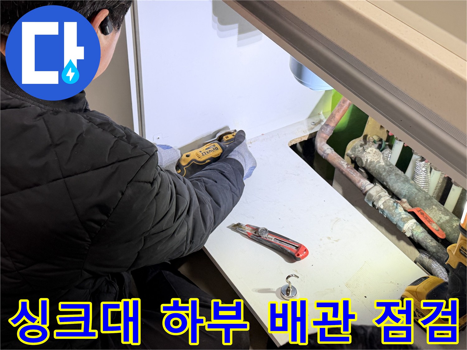 싱크대 밑 공간에서 작업자가 배관 상태를 확인하는 모습